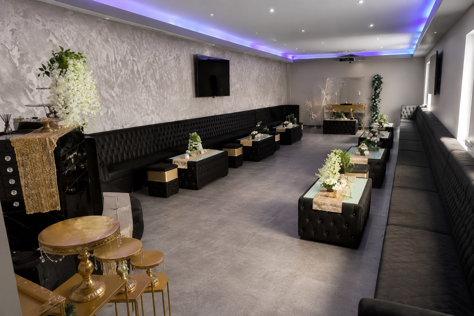 Eventraum Hagen — Saal mit schwarzen Chesterfield-Loungemöbeln, Goldtischen und LED-Deckenbeleuchtung